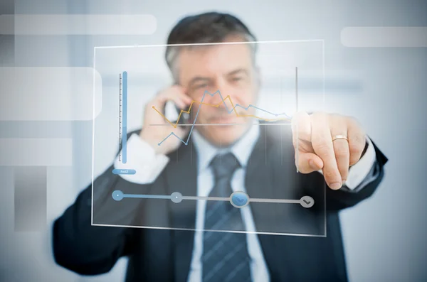 Businessman using futuristic touchscreen to view graph — Stock Photo, Image