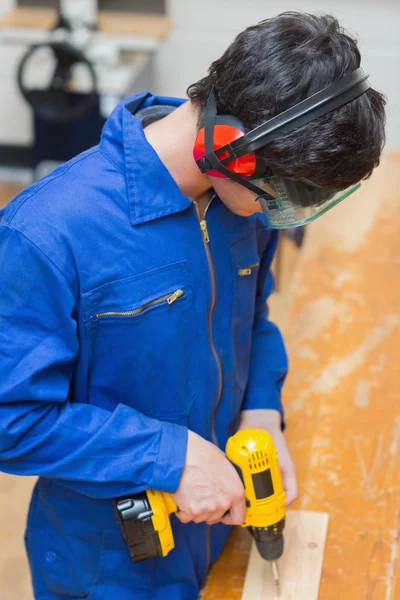 Studente su un banco di lavoro utilizzando il trapano — Foto Stock