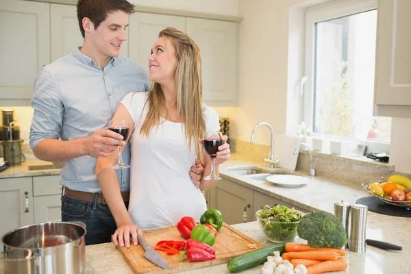 Par njuter av dricka vin och matlagning — Stockfoto