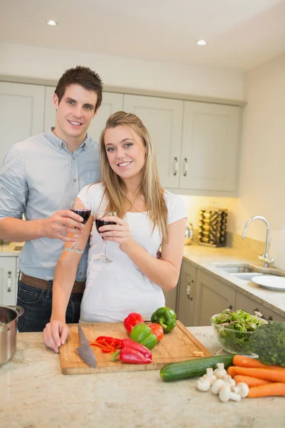 Man and woman cooking and clinking wine glasses — Stock Photo, Image