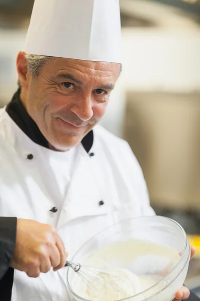 Smiling chef whisking cream — Stock Photo, Image