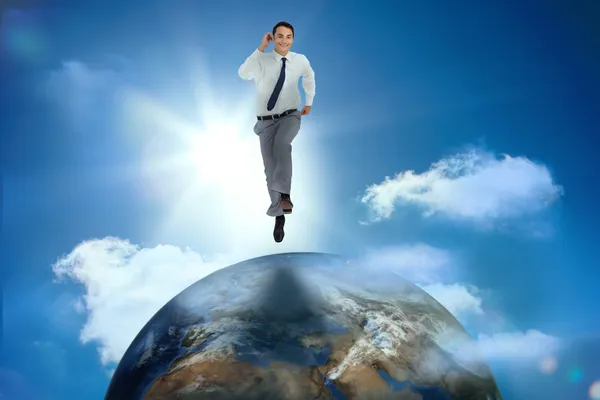Businessman racing on top of the world — Stock Photo, Image