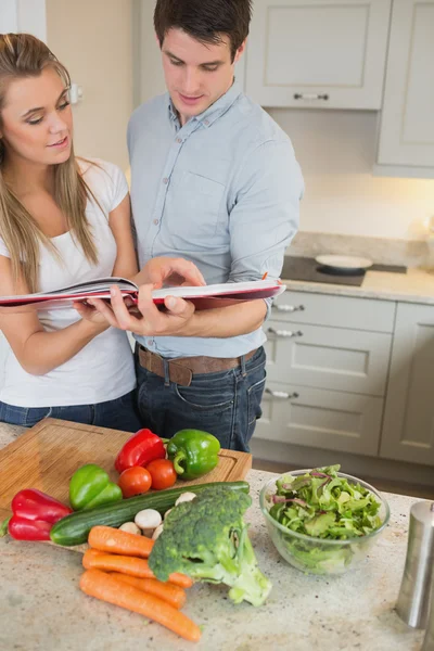 Couple reading cookery book — Stock Photo, Image