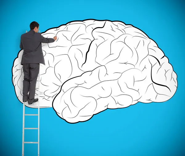 Empresario dibujando un cerebro en una pared gigante —  Fotos de Stock