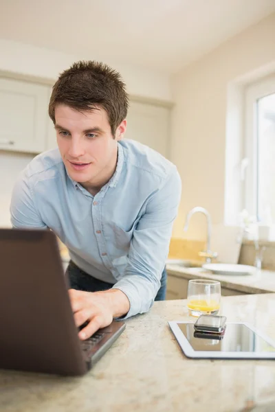 Homem no notebook com smartphone e tablet — Fotografia de Stock