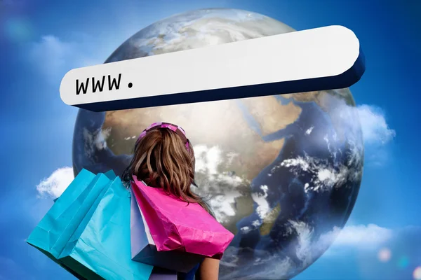 Girl with shopping bags looking at address bar with large earth — Stock Photo, Image