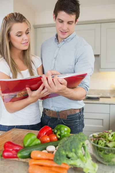 Couple reading cookbook together — Stock Photo, Image