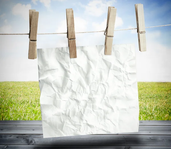 Papel blanco arrugado colgado en una línea de lavandería —  Fotos de Stock