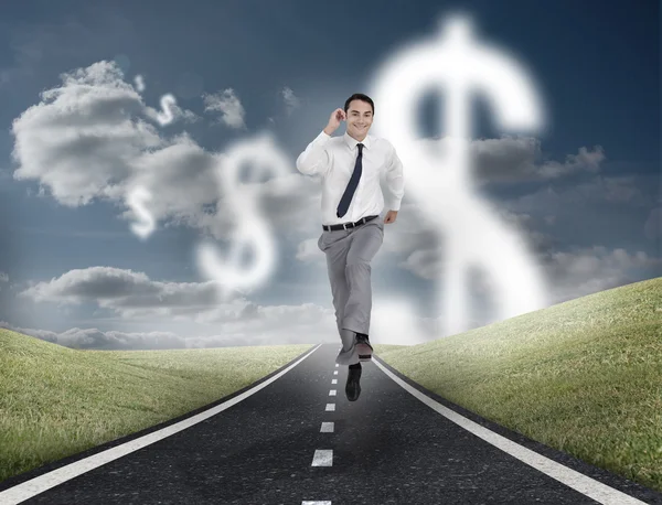 Dollar currency behind businessman running on a road — Stock Photo, Image