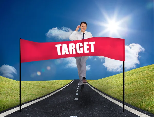 Young smiling businessman running on a road in the middle of green area — Stock Photo, Image