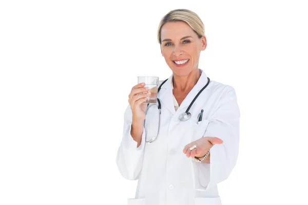 Médico feliz con pastillas y un vaso de agua en las manos —  Fotos de Stock