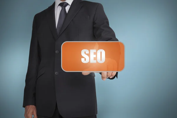 Businessman selecting orange tag with the word seo written on it — Stock Photo, Image