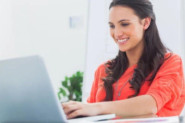 Uśmiechający się projektant pracujący na jej laptopie — Zdjęcie stockowe