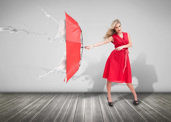 Attraktive Frau, die einen Regenschirm hält, um sich vor dem — Stockfoto