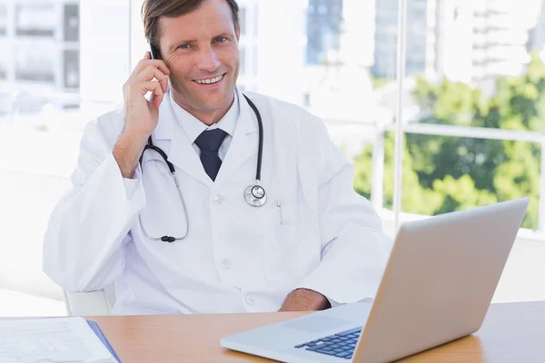 Médico feliz telefonando em seu escritório — Fotografia de Stock