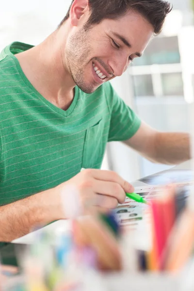 Editeur photo souriant travaillant sur une feuille de contact — Photo