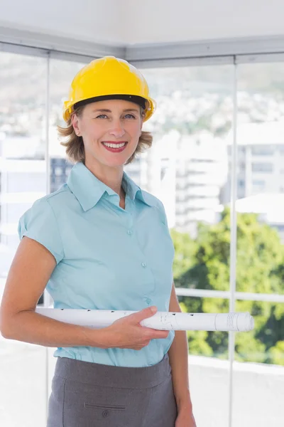 Architecte regardant caméra avec casque et plan — Photo