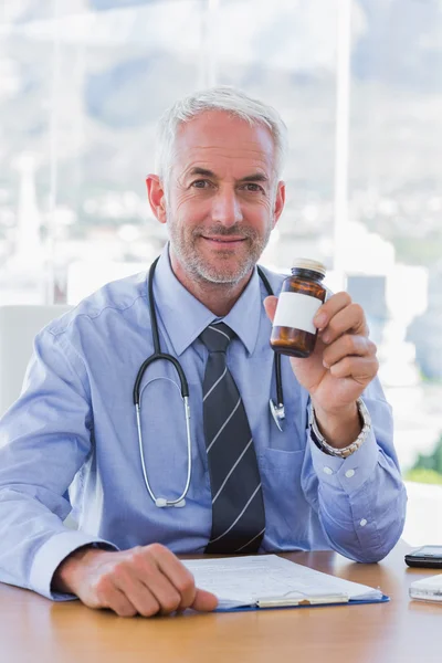 Привлекательный доктор держит банку с лекарствами — стоковое фото