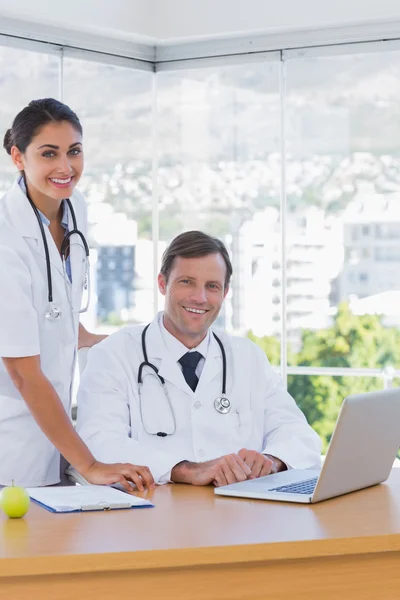 Médecins joyeux posant ensemble dans leur bureau — Photo