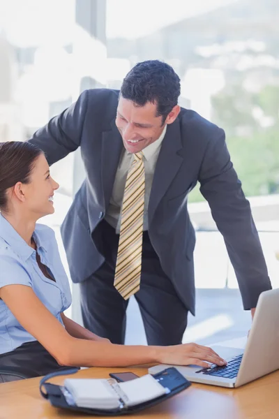 Smiling business working together with a laptop — Stock Photo, Image