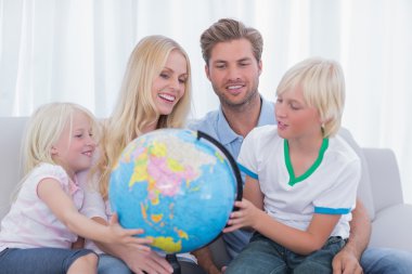 Family looking at globe together clipart