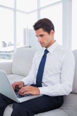 Attractive businessman typing on his laptop clipart