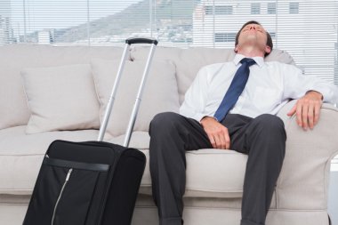 Businessman napping on couch clipart