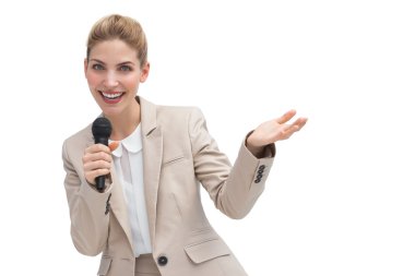 Gesturing businesswoman speaking on microphone clipart
