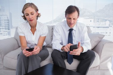 Business typing on their mobile phones clipart