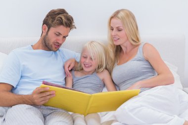 Couple reading a story to daughter clipart