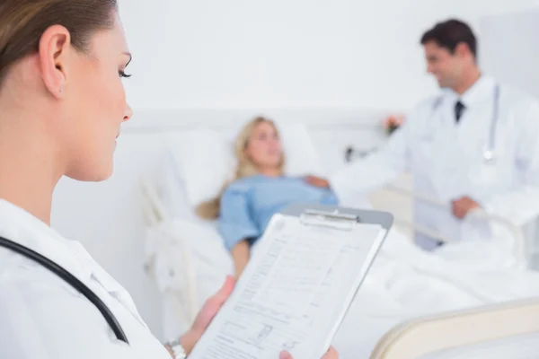 Doctor reading folder of a patient — Stock Photo, Image