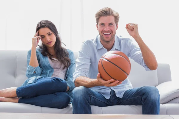 Жінка дратує свого партнера, дивлячись баскетбольну гру — стокове фото