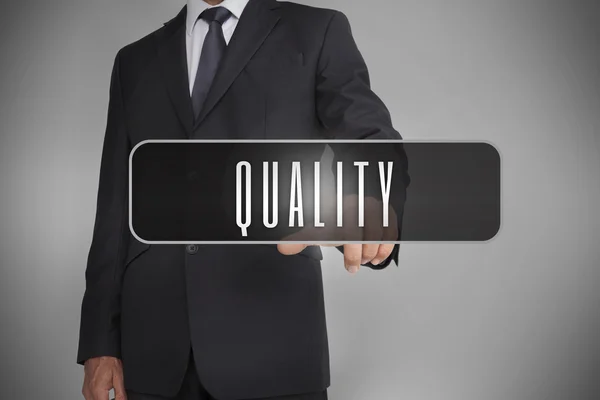 Businessman selecting label with quality written on it — Stock Photo, Image