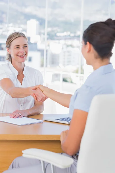 Entrevistador alegre estrechando la mano de un solicitante — Foto de Stock