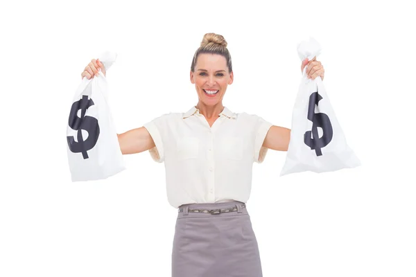 Smiling businesswoman holding money bags — Stock Photo, Image