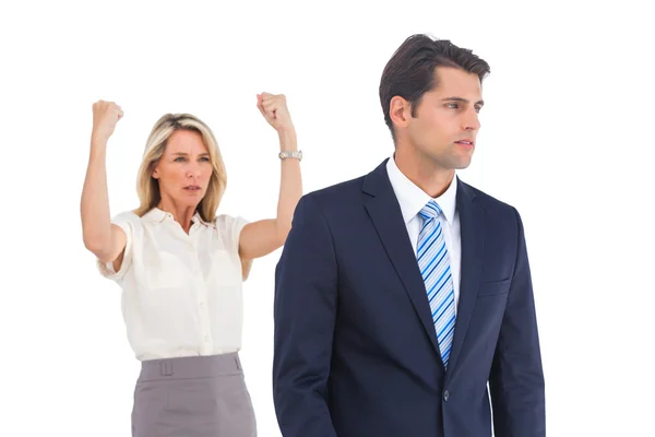 Businessman and a serious businesswoman with raised arms — Stock Photo, Image