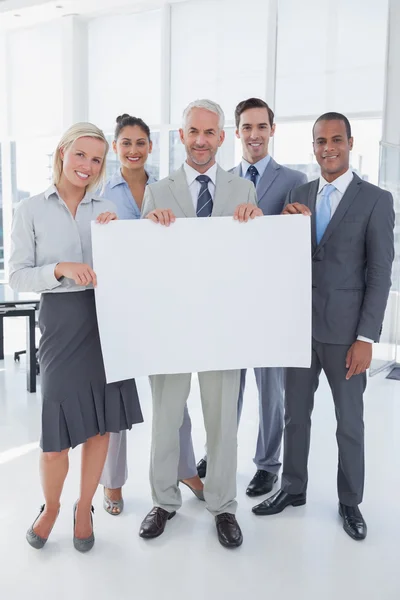 Happy business team holding large blank poster — Stock Photo, Image