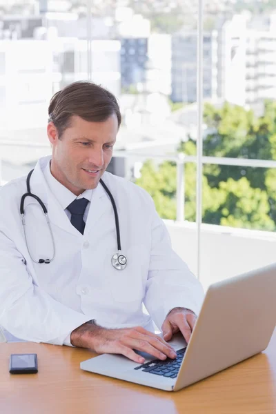 Alegre médico trabajando en un ordenador portátil —  Fotos de Stock