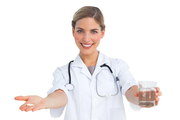 Lachende verpleegster geven drugs en waterglas — Stockfoto