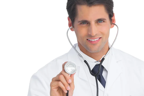 Dottore sorridente e tenendo in mano lo stetoscopio — Foto Stock