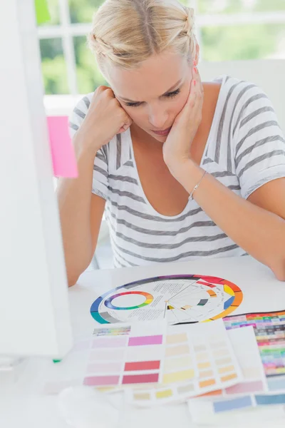 Thoughtful interior designer looking at a colour wheel — Stock Photo, Image