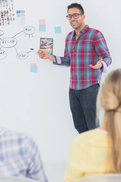 Stilig inredningsarkitekt pekar på en vägg — Stockfoto