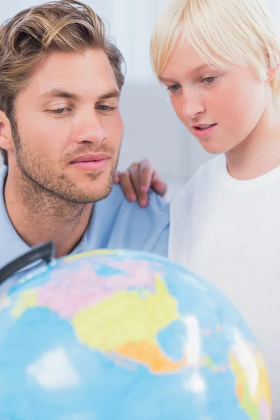 Father and son looking at globe together — Stock Photo, Image