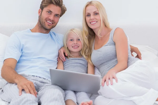 Family using a laptop in bed — Stock Photo, Image