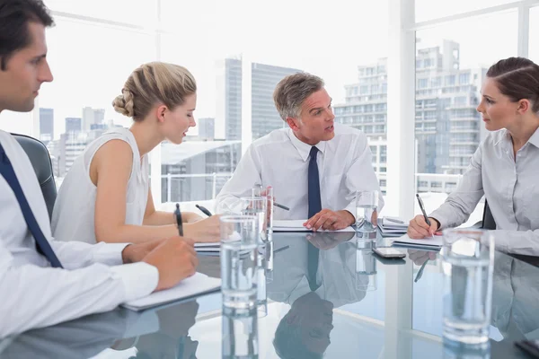 Seriöser Geschäftsmann während einer Besprechung mit seinen Mitarbeitern — Stockfoto