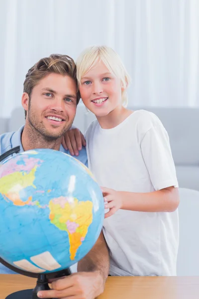 Pai e seu menino olhando para o globo — Fotografia de Stock