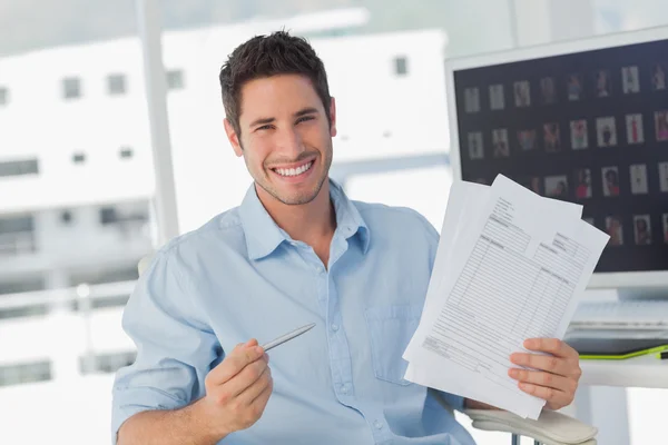 Cheerful photo editor pointing at documents — Stock Photo, Image