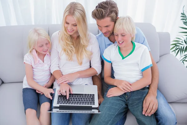 Família alegre usando laptop — Fotografia de Stock