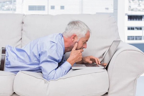 Zakenman liggend op de Bank met laptop — Stockfoto