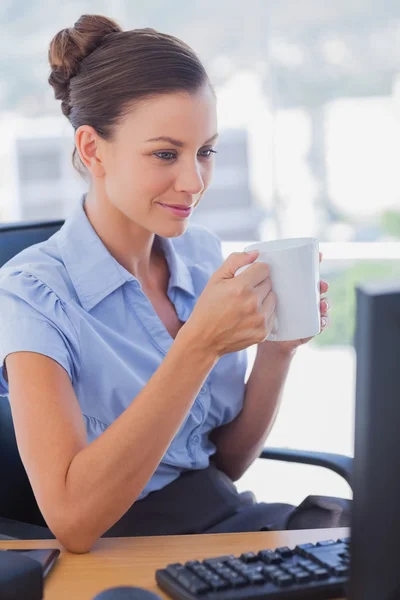 Businesswoman holding her mug and smiling — Stock Photo, Image